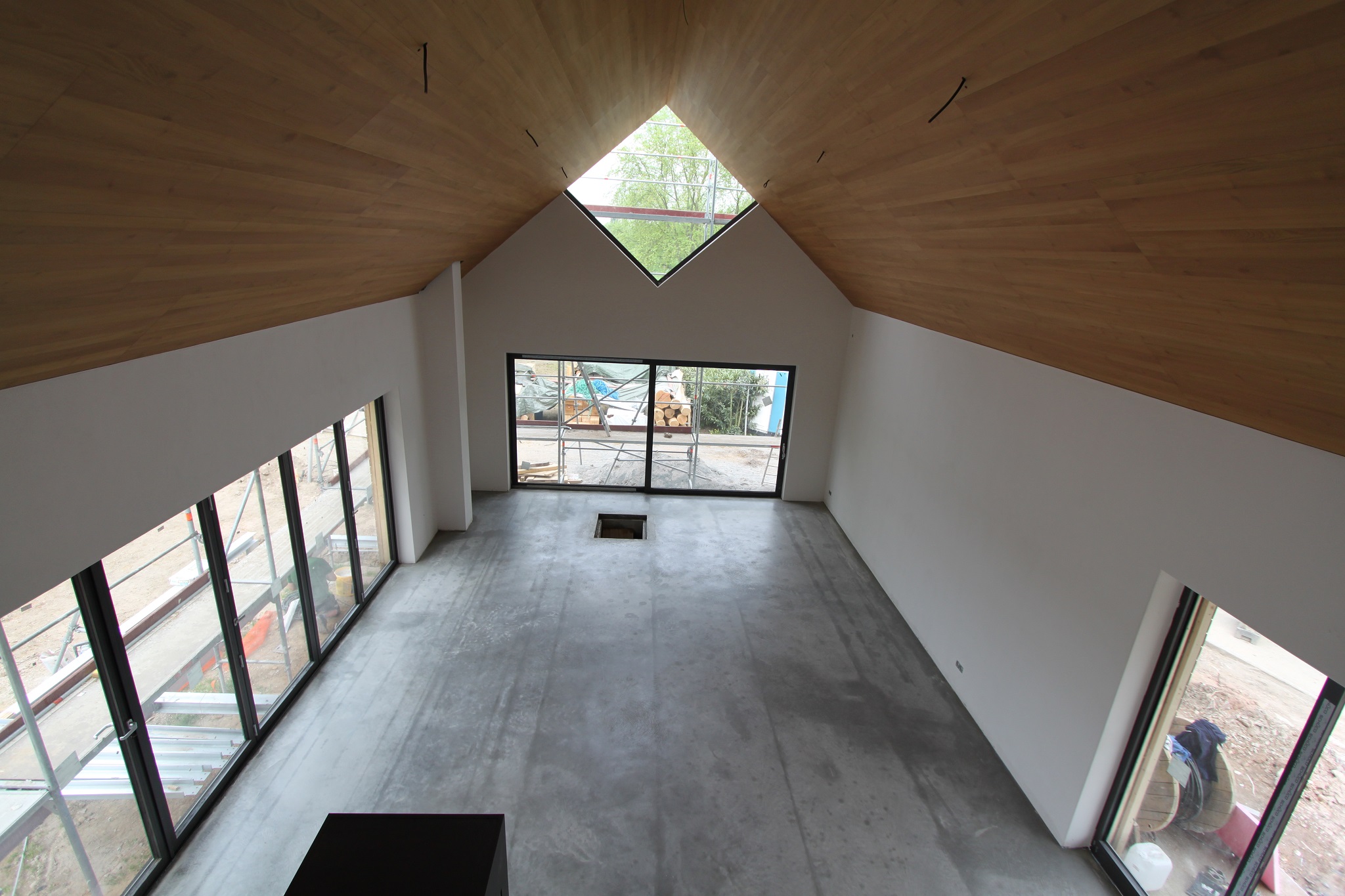 Sichtestrichfläche in einem Raum mit Holzdecke und Fensterfront