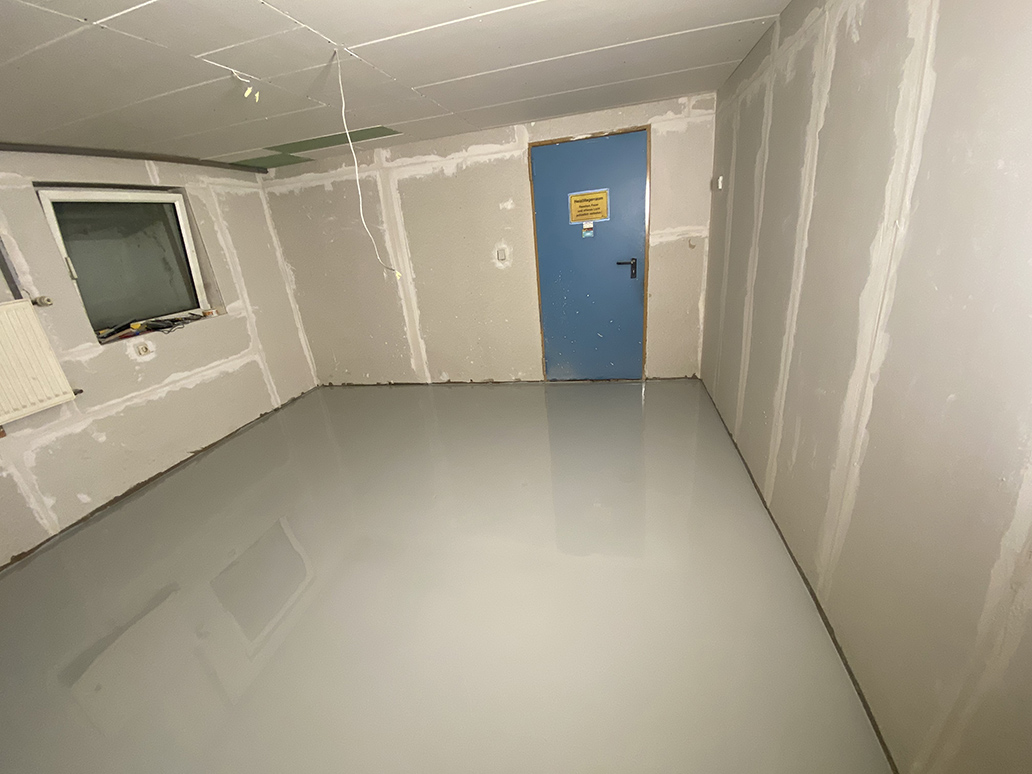 Hellgraue Bodenbeschichtung in einem Kellerraum