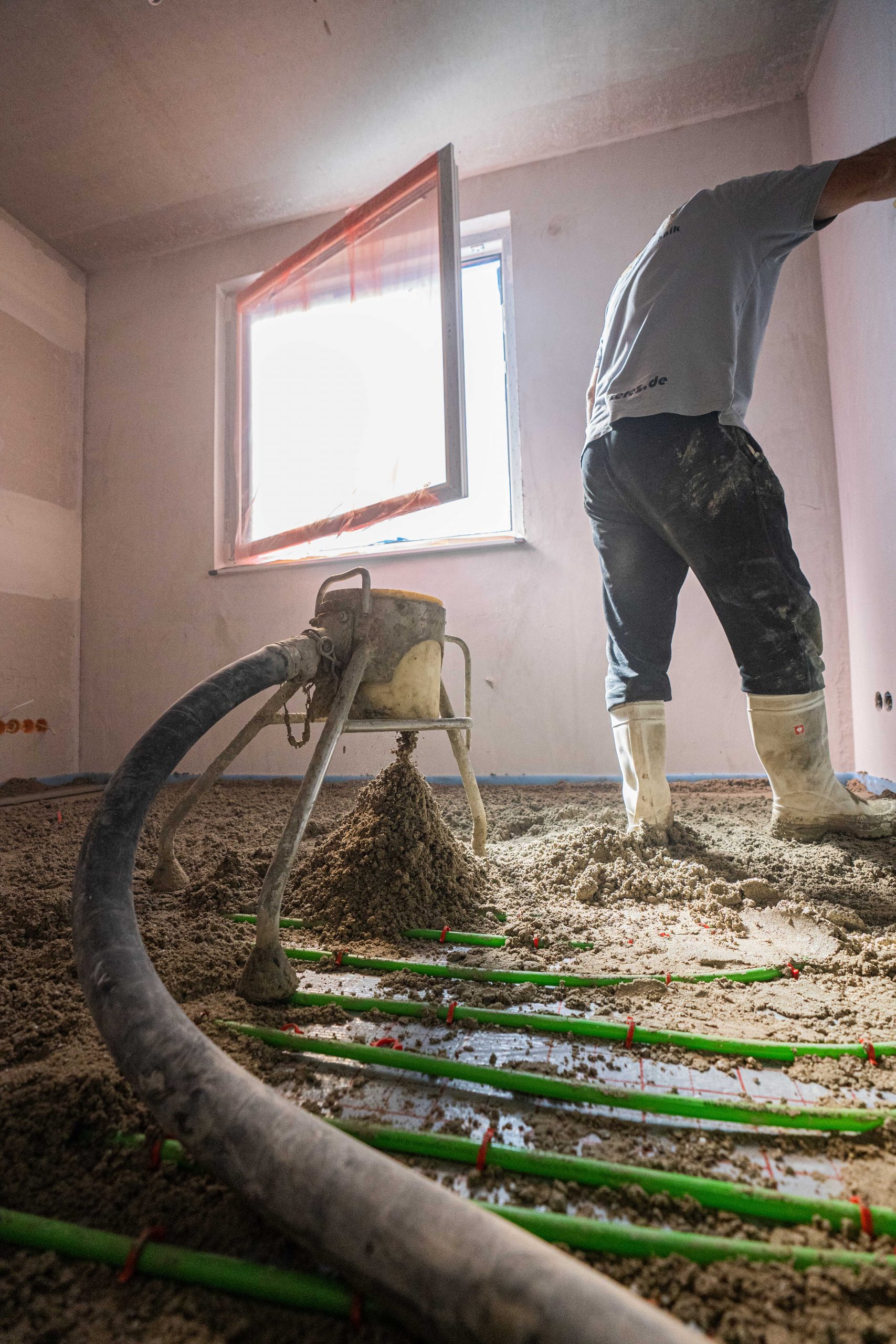 Estrichschlauch über verlegten Heizrohren auf der Baustelle