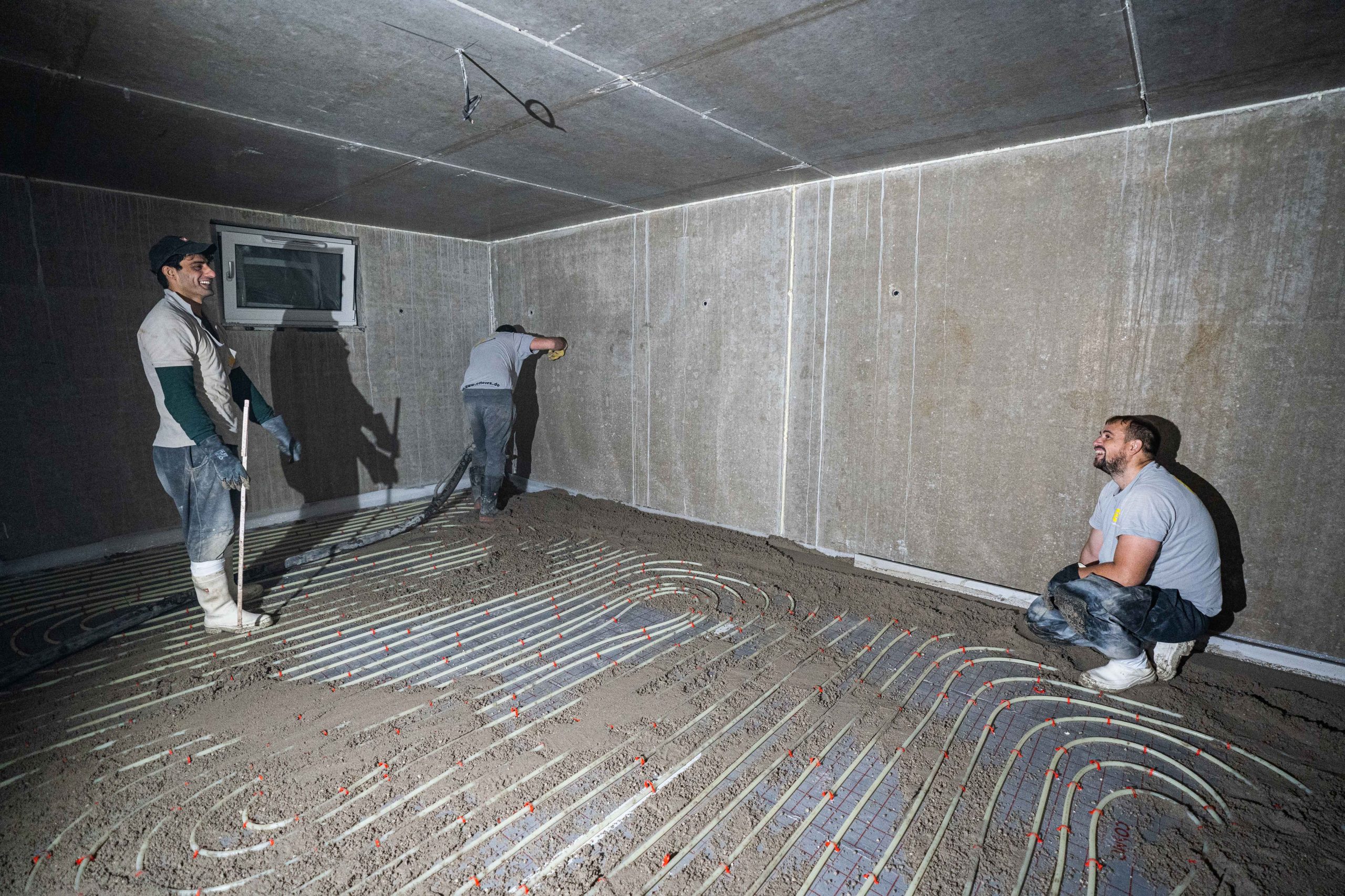 Mitarbeiter arbeiten an einer Fläche mit verlegter Fußbodenheizung